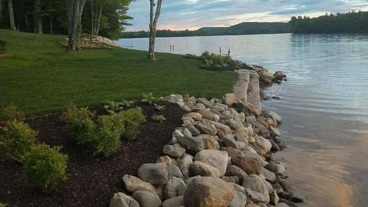 A woman is cleaning a computer monitor in an office.