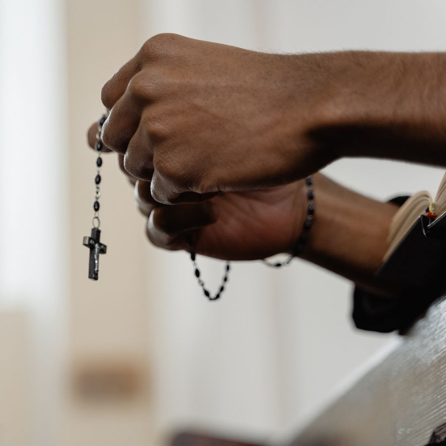 Person praying with rosary