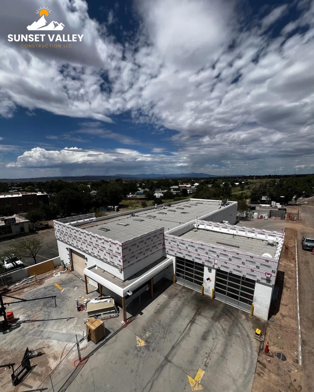 New Sunset Valley fire station under construction, with open garage doors and cloudy sky.