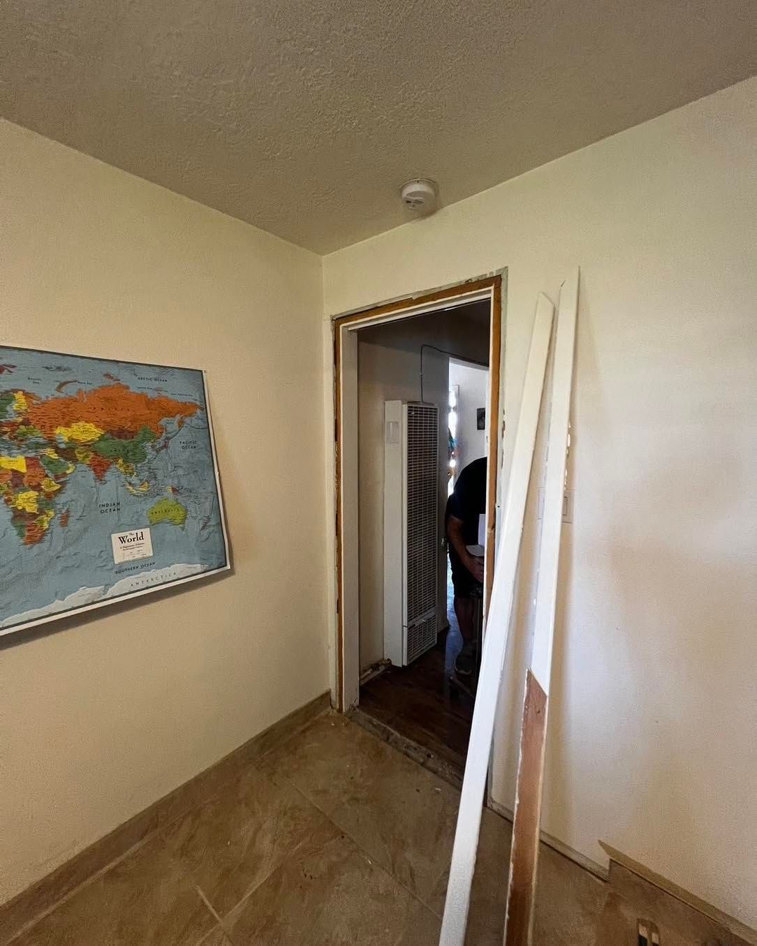 Doorway with trim and a world map on wall.