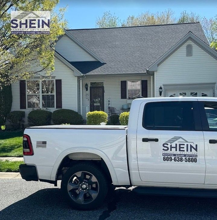 White SHEIN pickup truck parked in front of a suburban house with a SHEIN sign in the yard