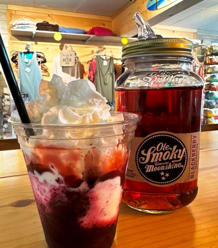 A glass of Ole Smoky Moonshine next to a jar of it.