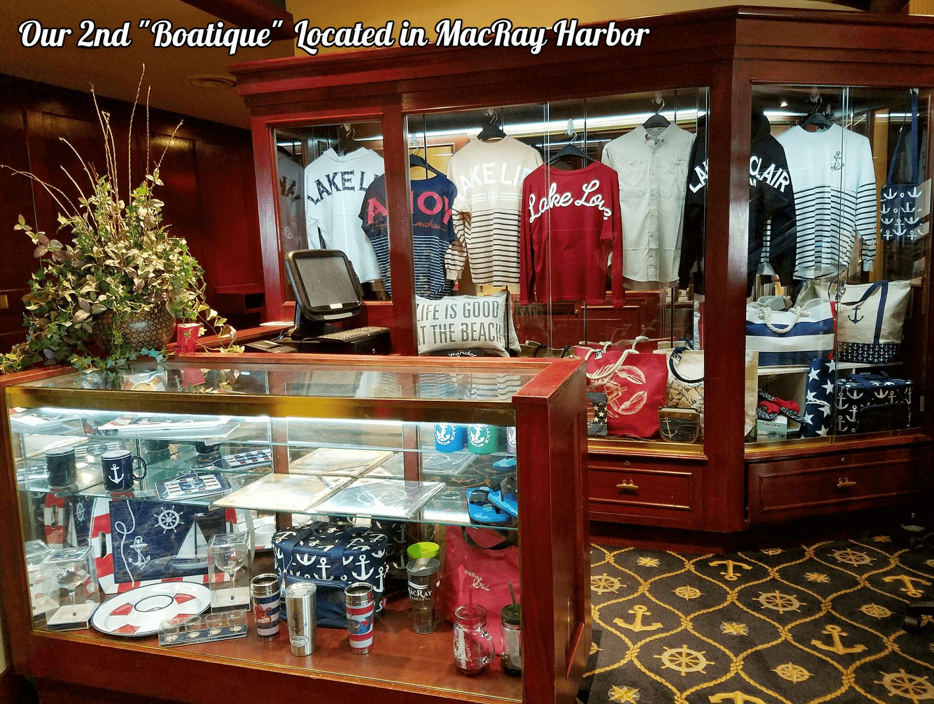 Boutique display with clothing and accessories in a wooden cabinet. Located in Macray Harbor.