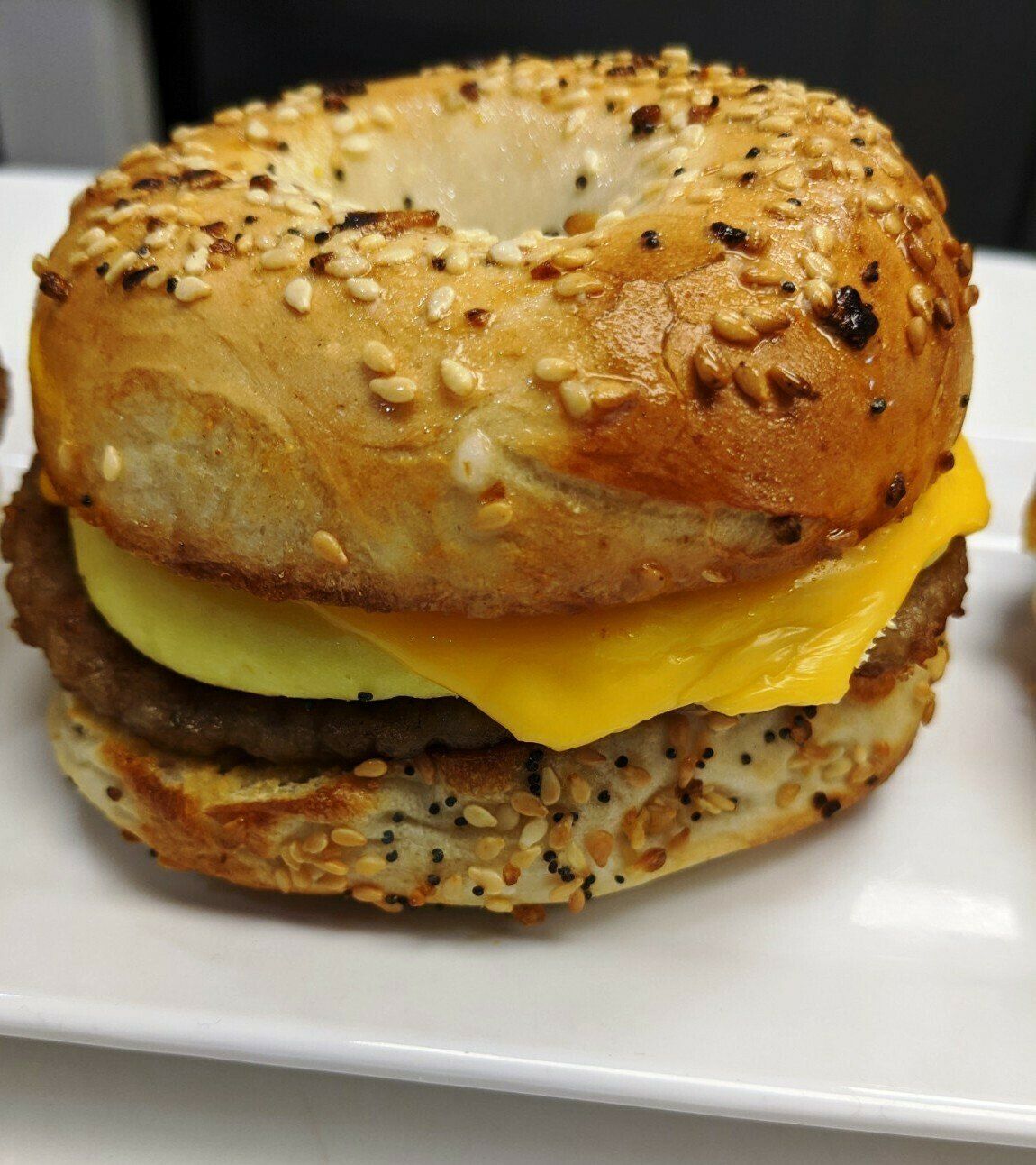 Everything bagel breakfast sandwich with sausage patty, egg, and cheese.