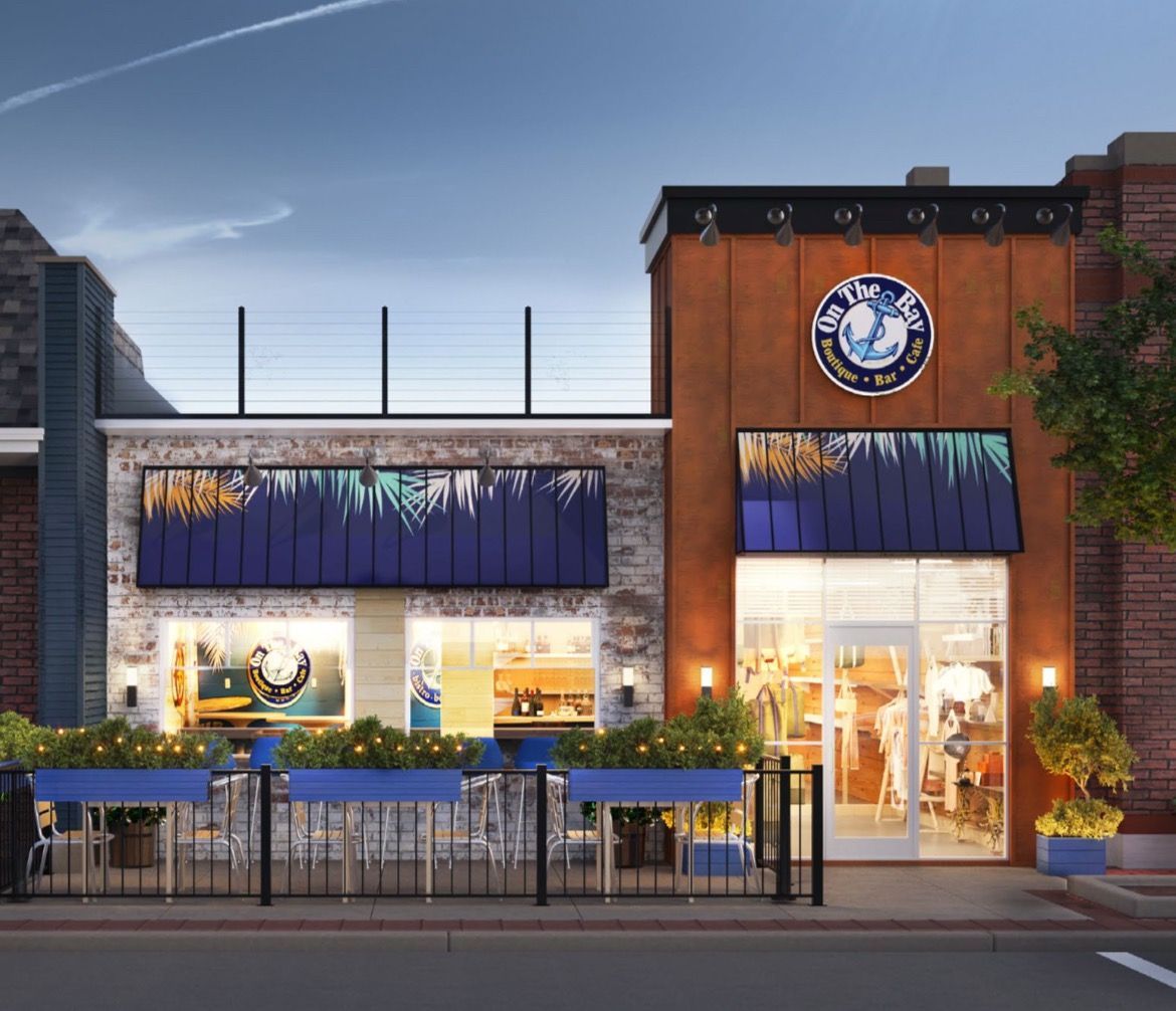 A restaurant storefront with a rust-colored tower, blue awnings with palm tree graphics, and a patio dining area.