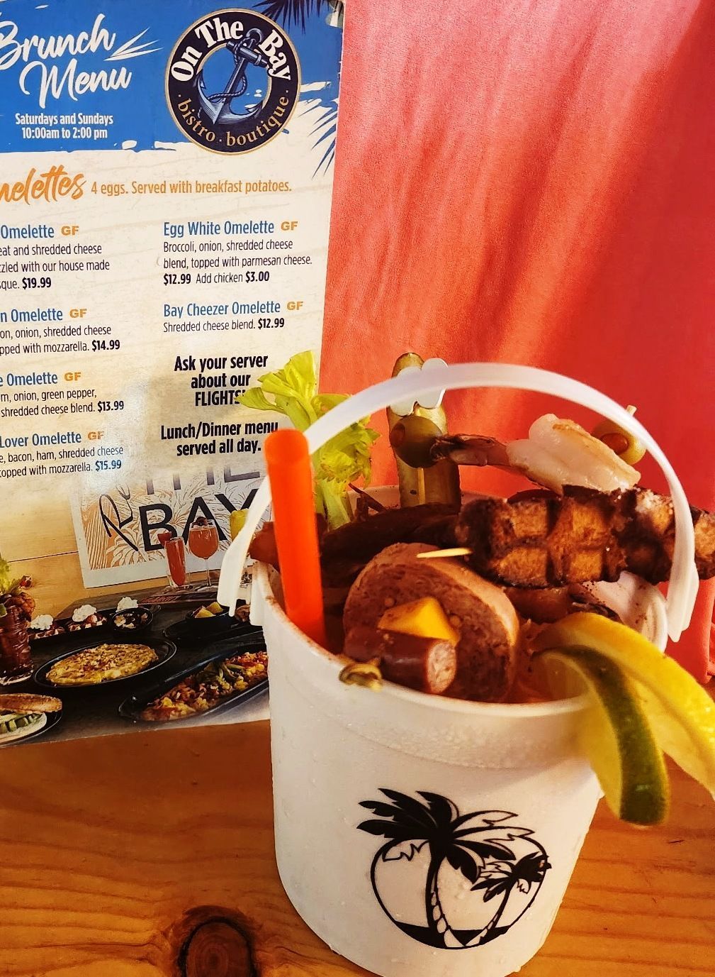 Bloody Mary cocktail bucket with food skewers, menu background.
