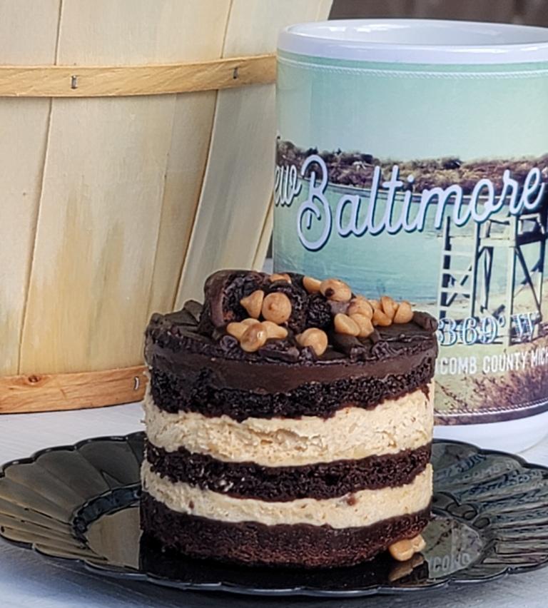 Chocolate peanut butter cake on a black plate next to a