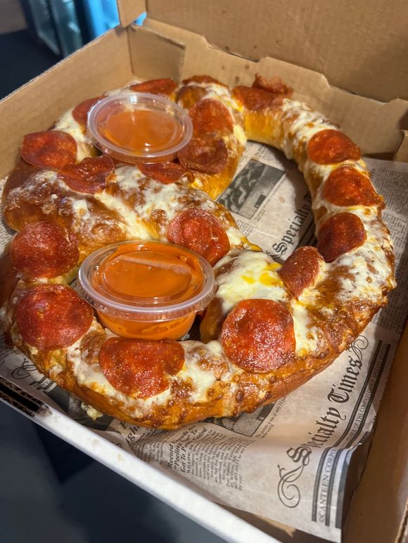 A pizza wreath with pepperoni and cheese in a box.
