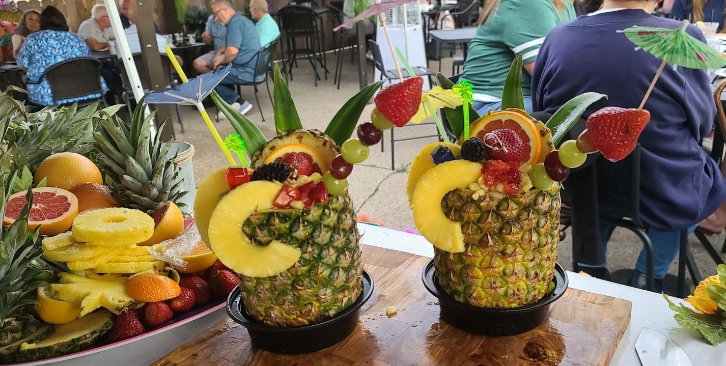 Two pineapples filled with fruit are sitting on a table