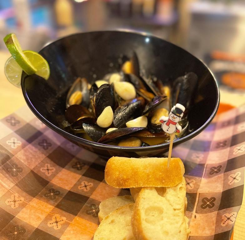 A bowl of mussels with a snowman on a toothpick.