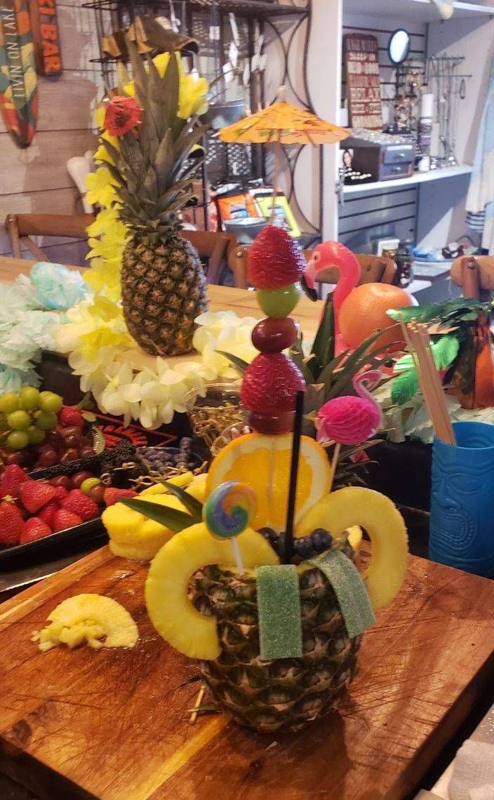 A pineapple filled with fruit is sitting on a wooden table.