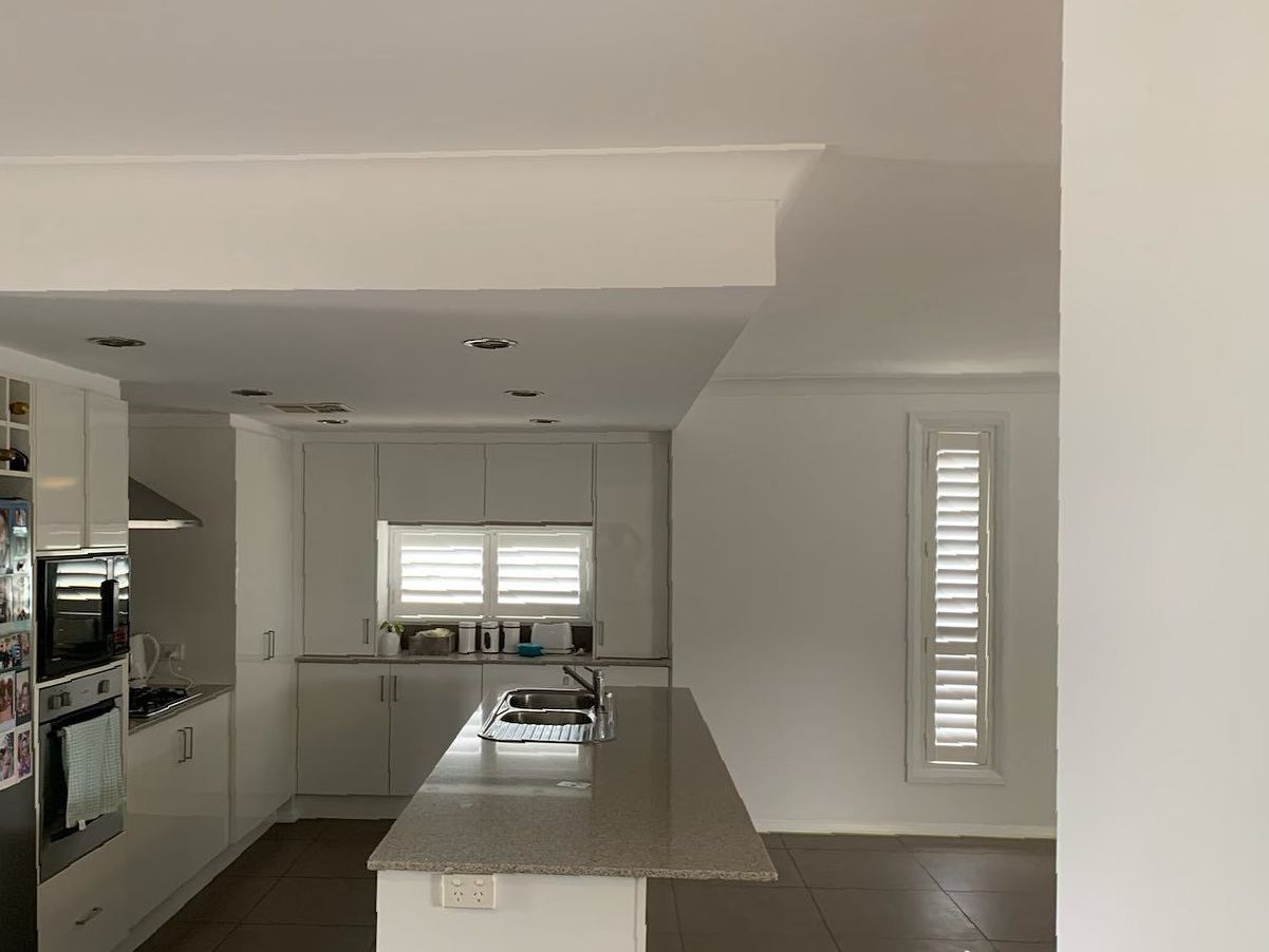 A Kitchen With White Cabinets and Granite Counter Tops — The Big Bearded Painter In Newcastle, NSW