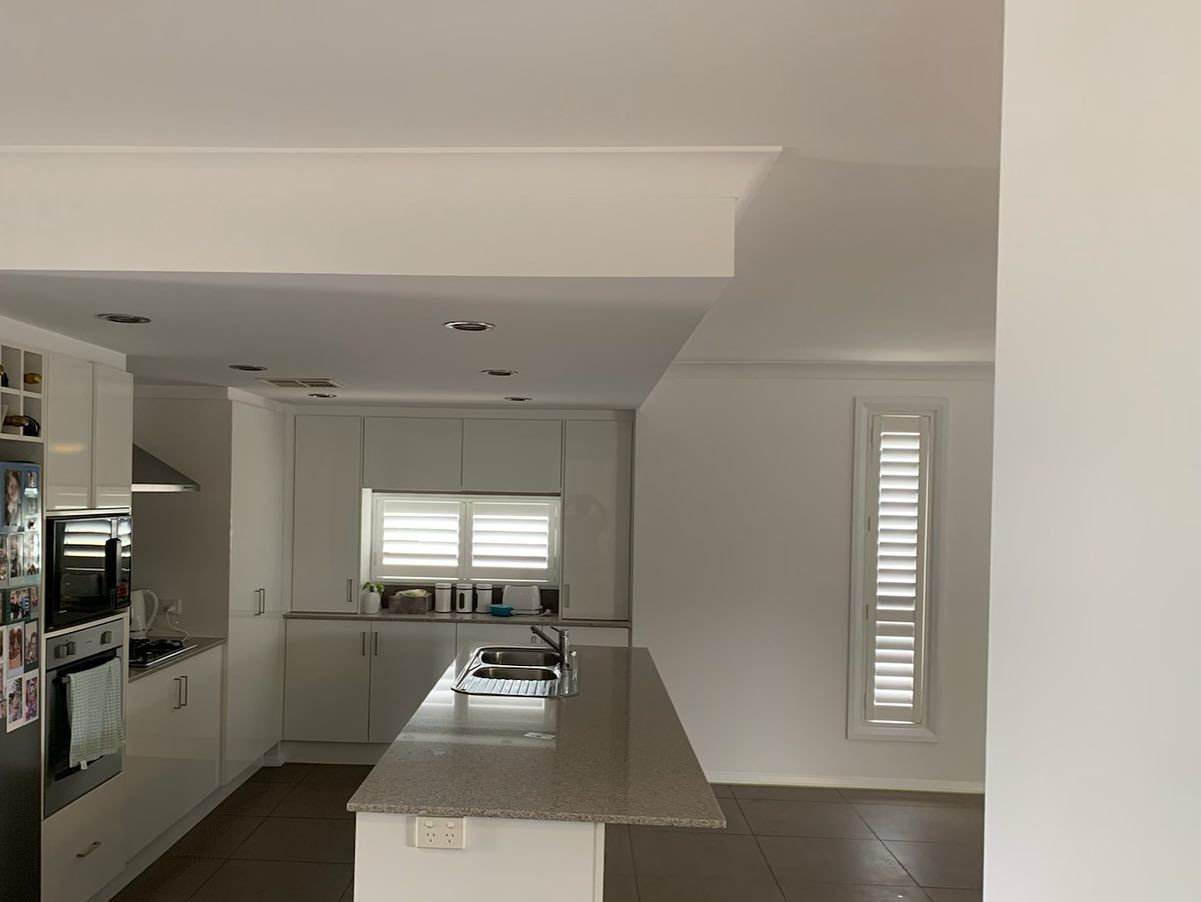 A Kitchen With White Cabinets and Granite Counter Tops — The Big Bearded Painter In Kurri Kurri, NSW
