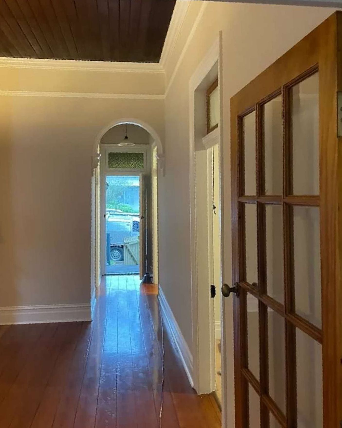 A Long Hallway With Hardwood Floors and a Wooden Door Leading to a Living Room — The Big Bearded Painter In Booral, NSW