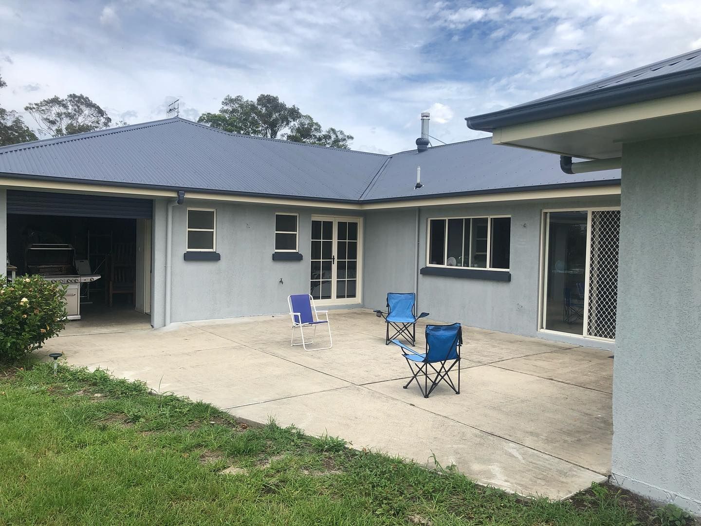 A House With a Blue Roof and a Patio With Chairs — The Big Bearded Painter In Booral, NSW