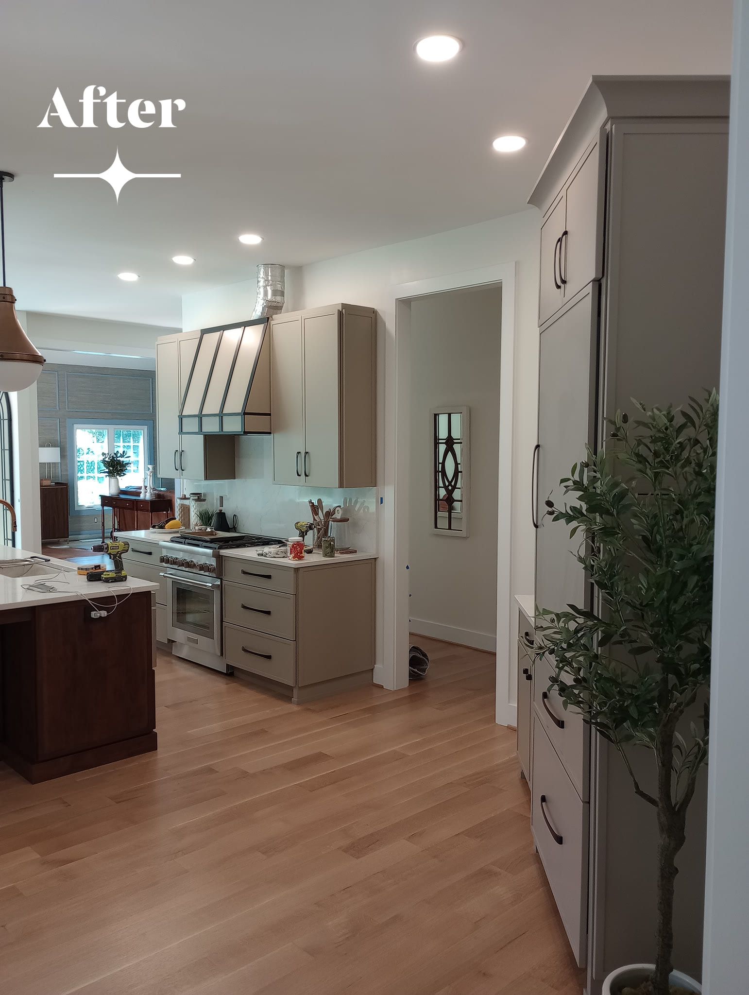 After: Kitchen with light cabinets, wood floors, and a plant.
