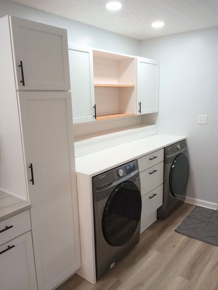 Laundry room with white cabinets, a countertop, and a washer/dryer.