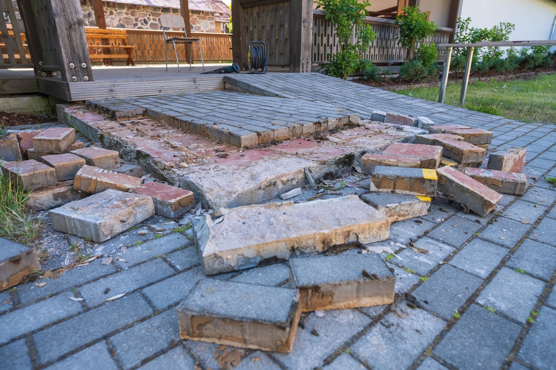 Damaged brick pathway in front of a building. Some bricks are broken and scattered. Damaged brick pathway in front of a building. Some bricks are broken and scattered.