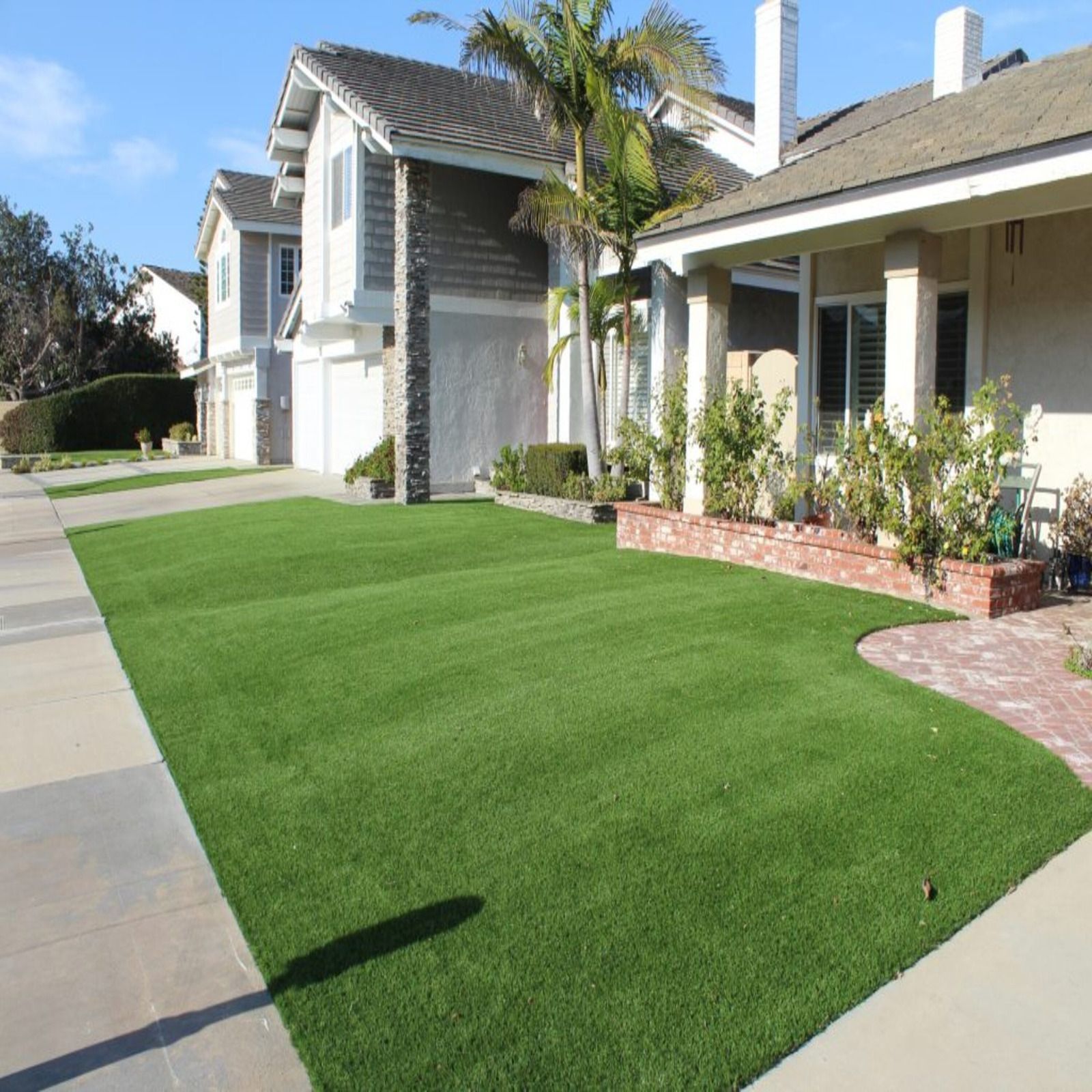 Houses with vibrant green lawns on a sunny day.