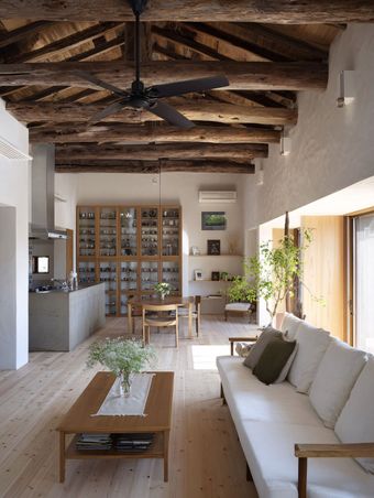 Construction worker installing insulation in a wall, wearing safety gear: hard hat, vest, and gloves.