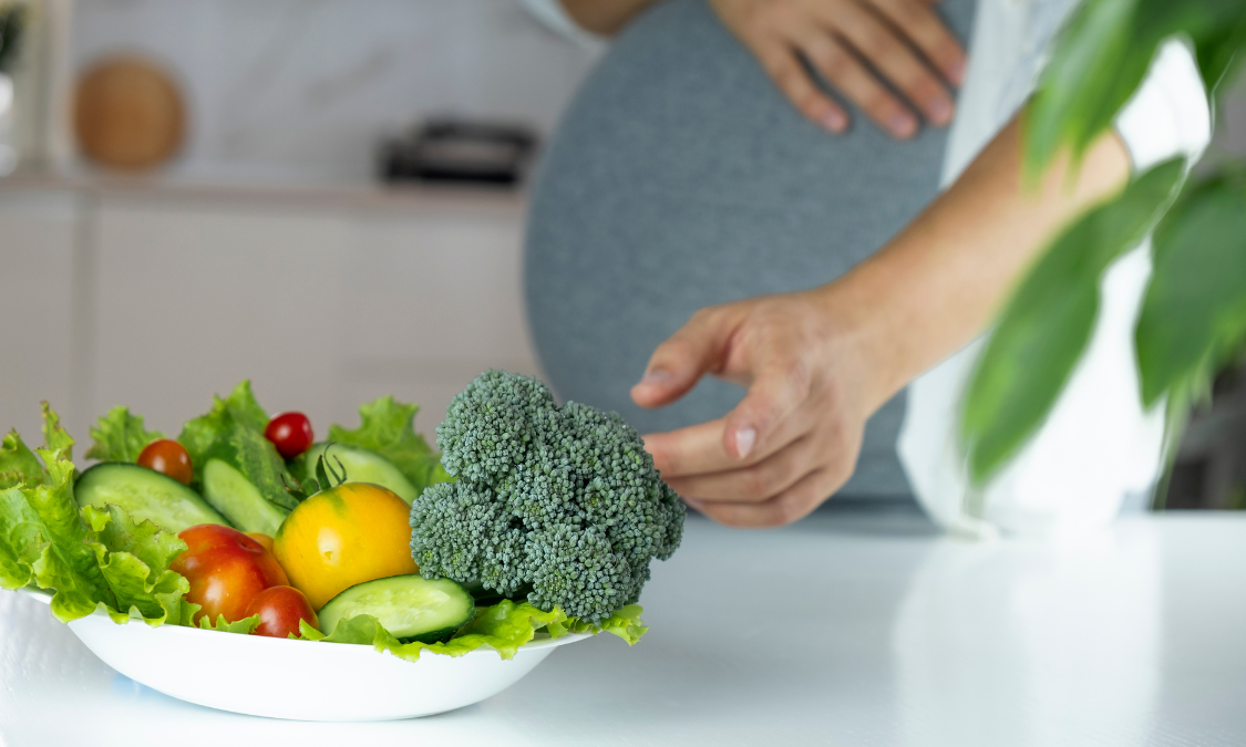 Woman in white shirt packing a mint green diaper bag in a bright room.