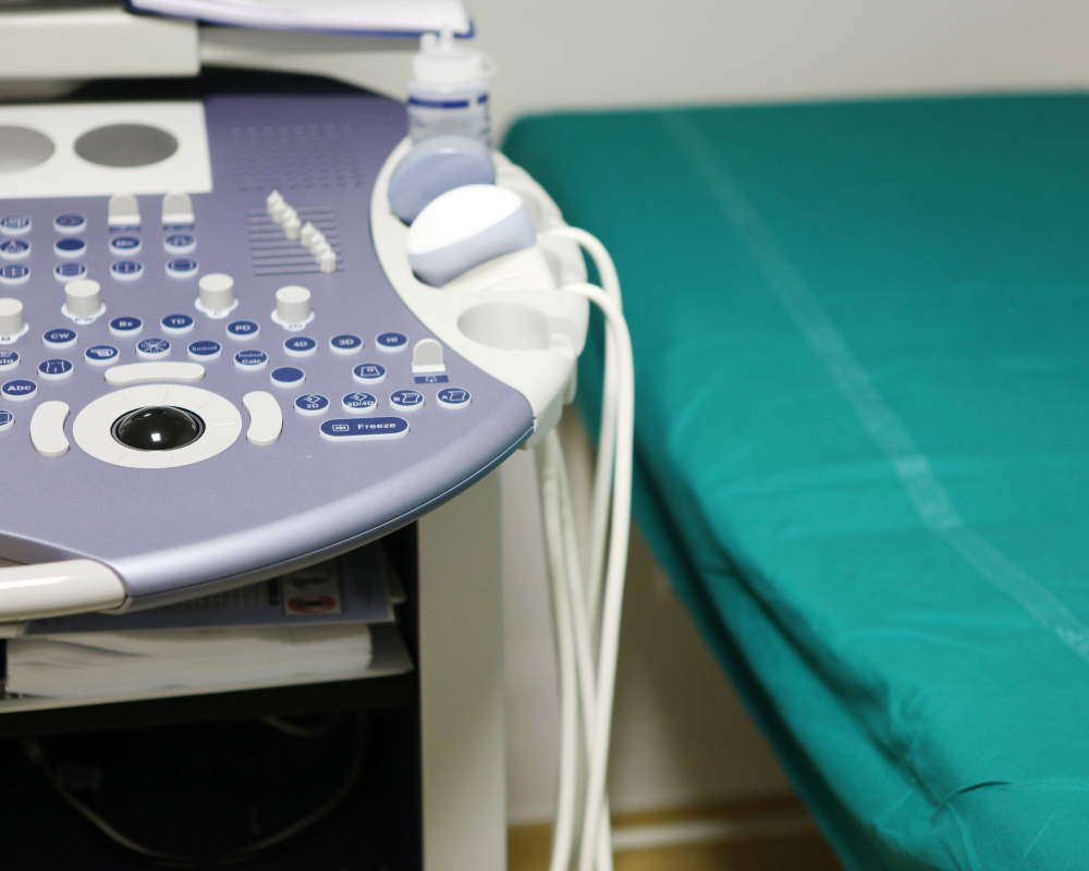 Ultrasound machine next to a patient examination table.