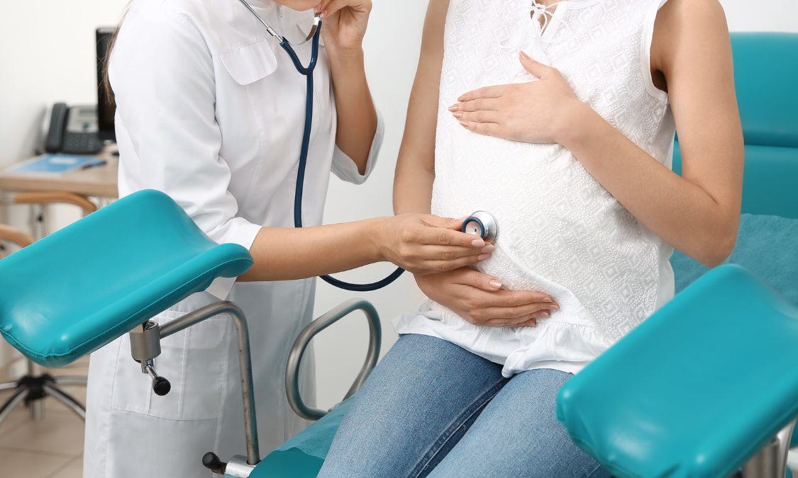 Four women in workout clothes doing side plank yoga poses in a home studio.