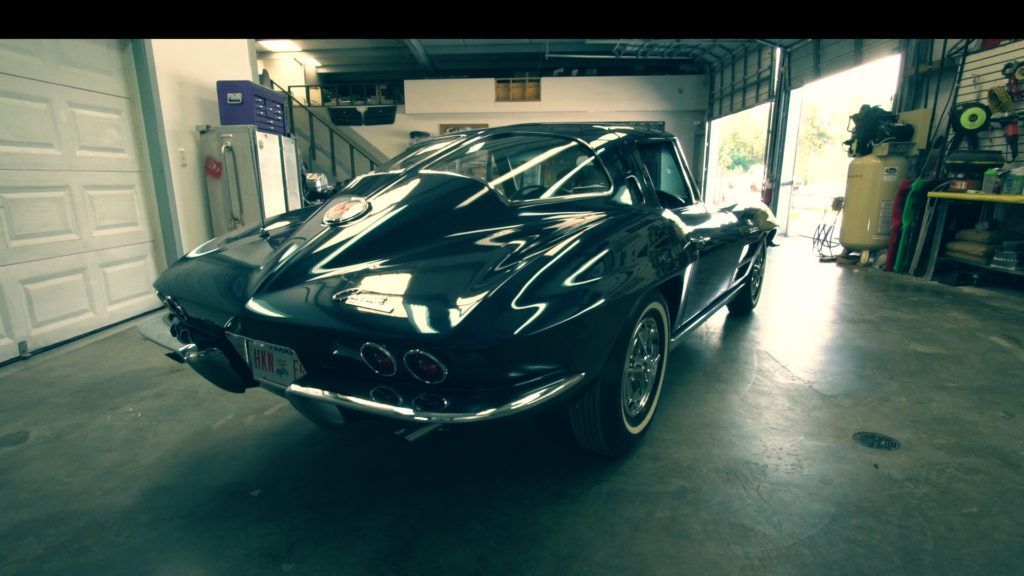 Black Corvette inside a garage.