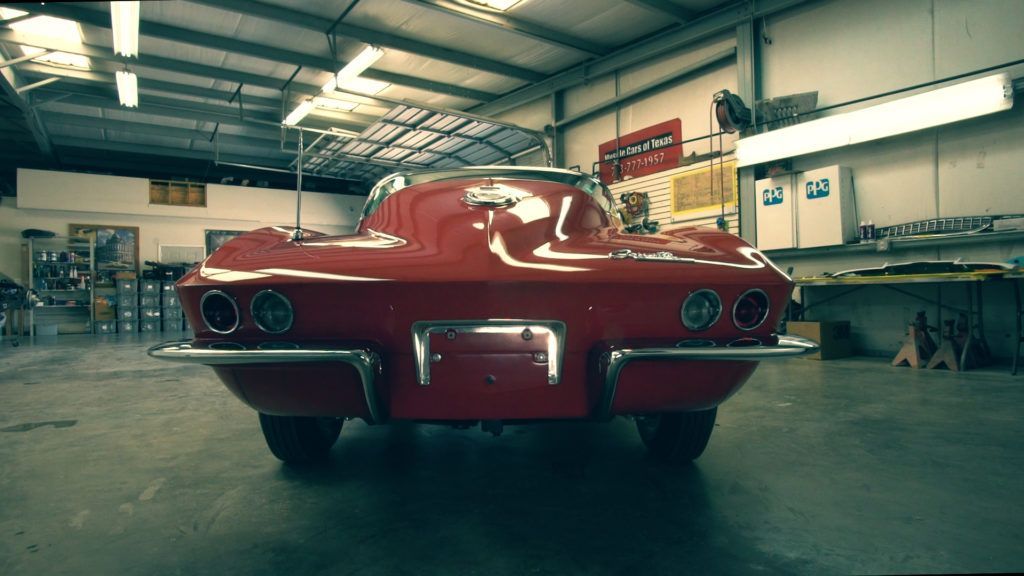 Red classic Corvette in a garage.