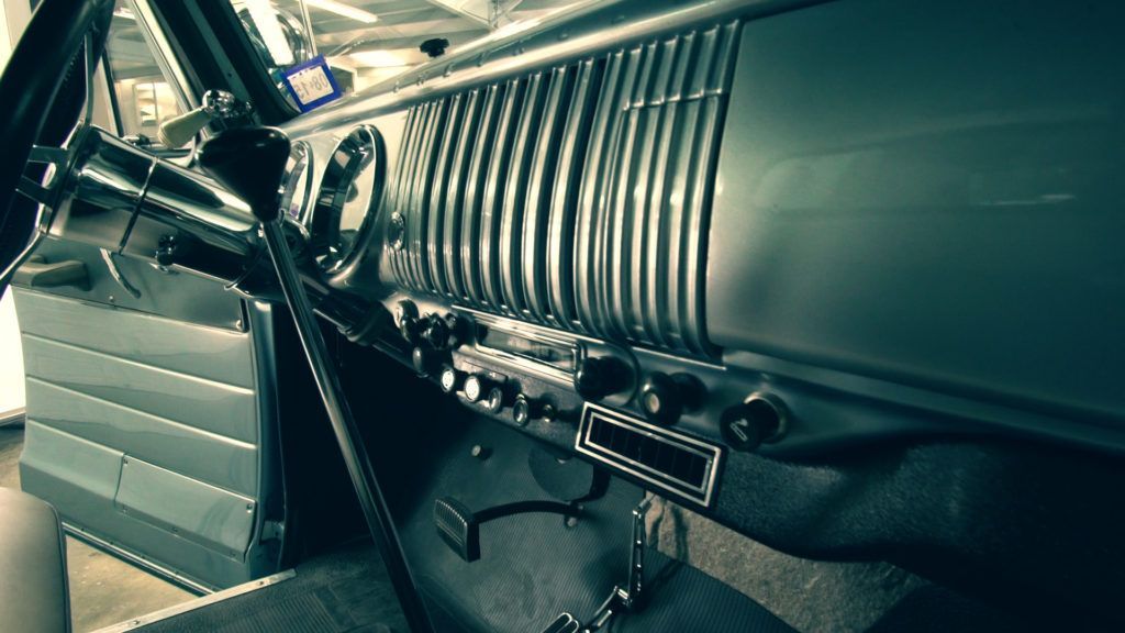 Interior of a classic car, dashboard with chrome details.