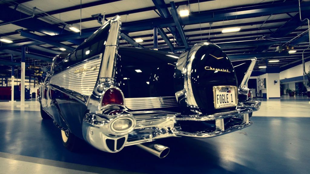 Black classic Chevrolet Bel Air with chrome accents, in a spacious garage.