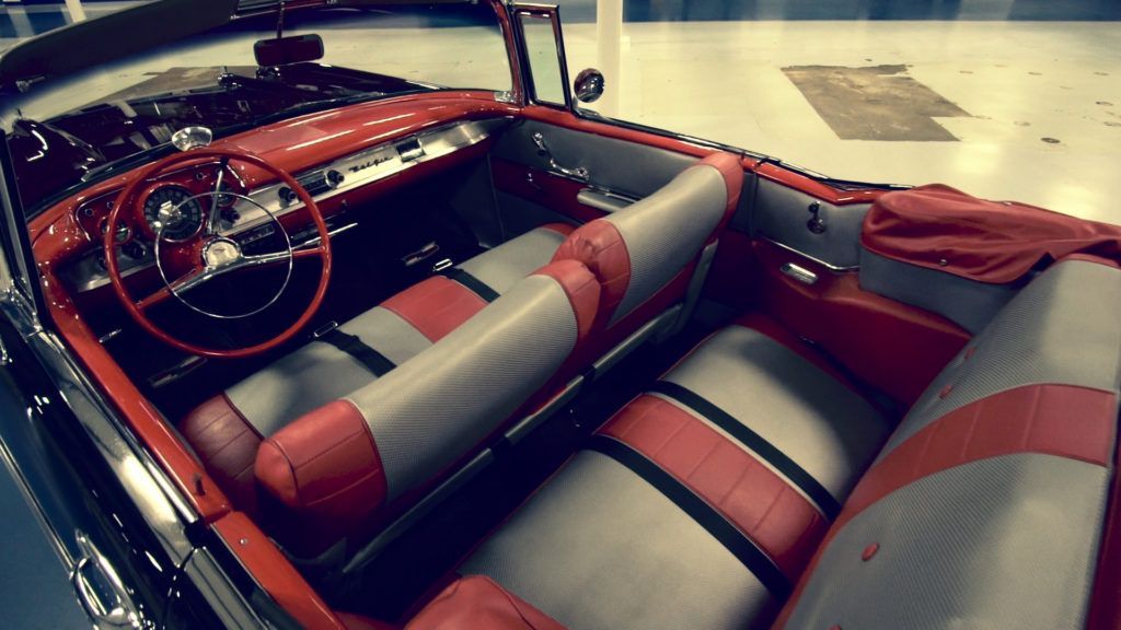 Red and gray interior of a classic convertible car.