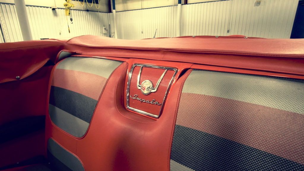 Red and striped car seat with a chrome and skull emblem.
