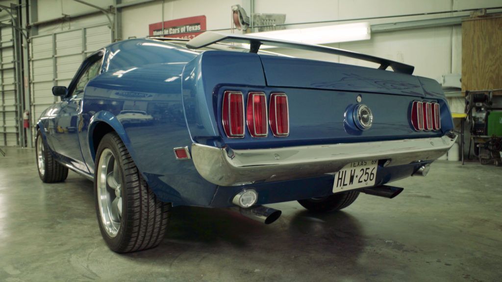 Blue classic Ford Mustang parked inside a garage.