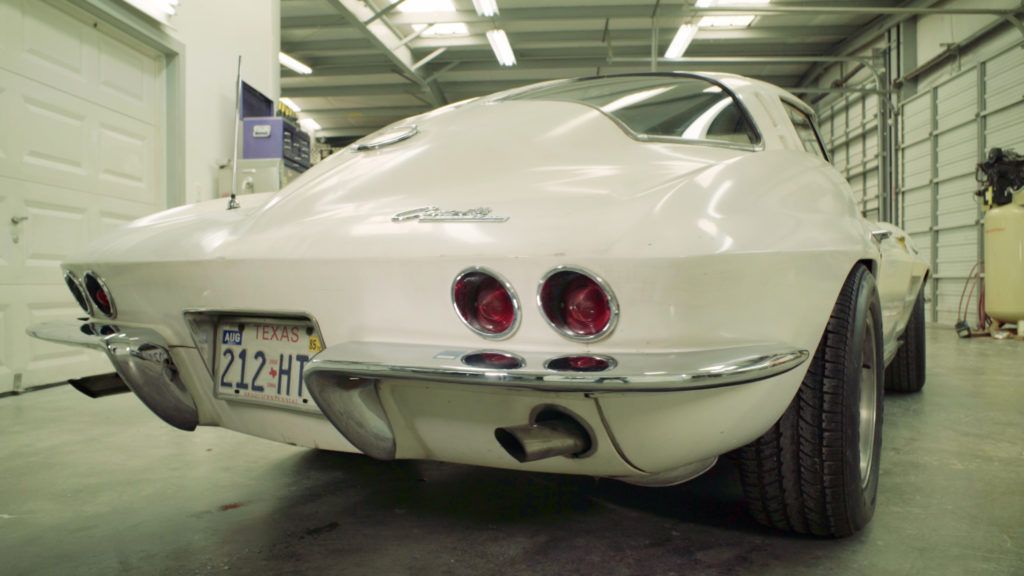 White classic Corvette sports car, back view, in a garage.