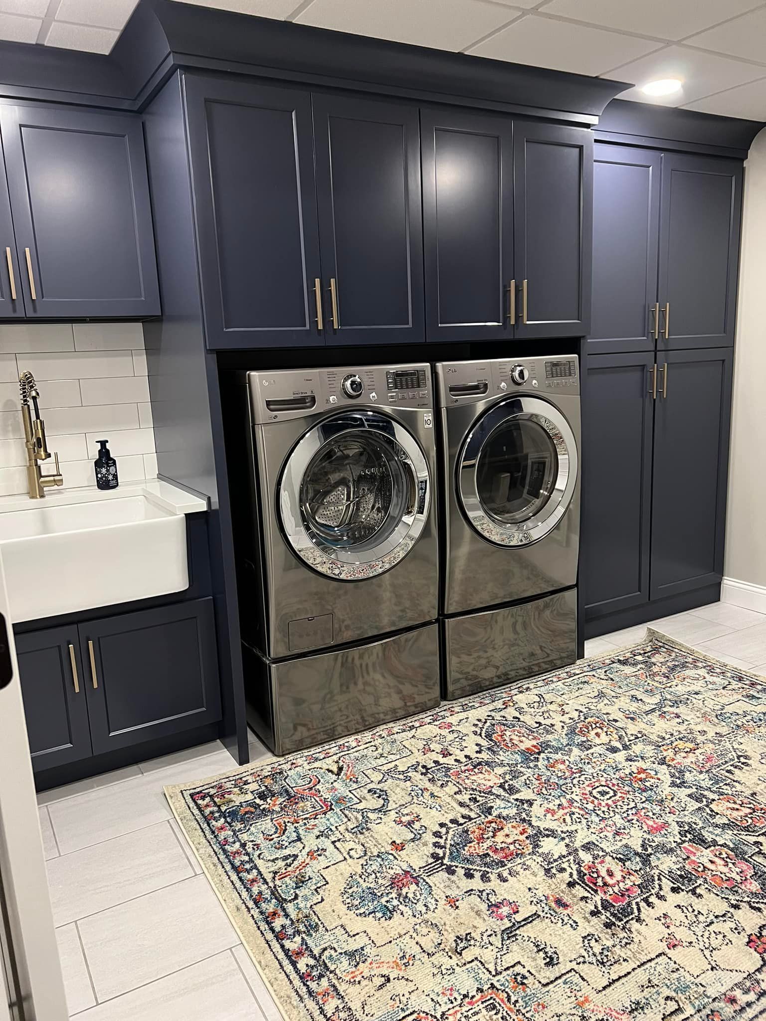 A laundry room with a washer and dryer and a rug.