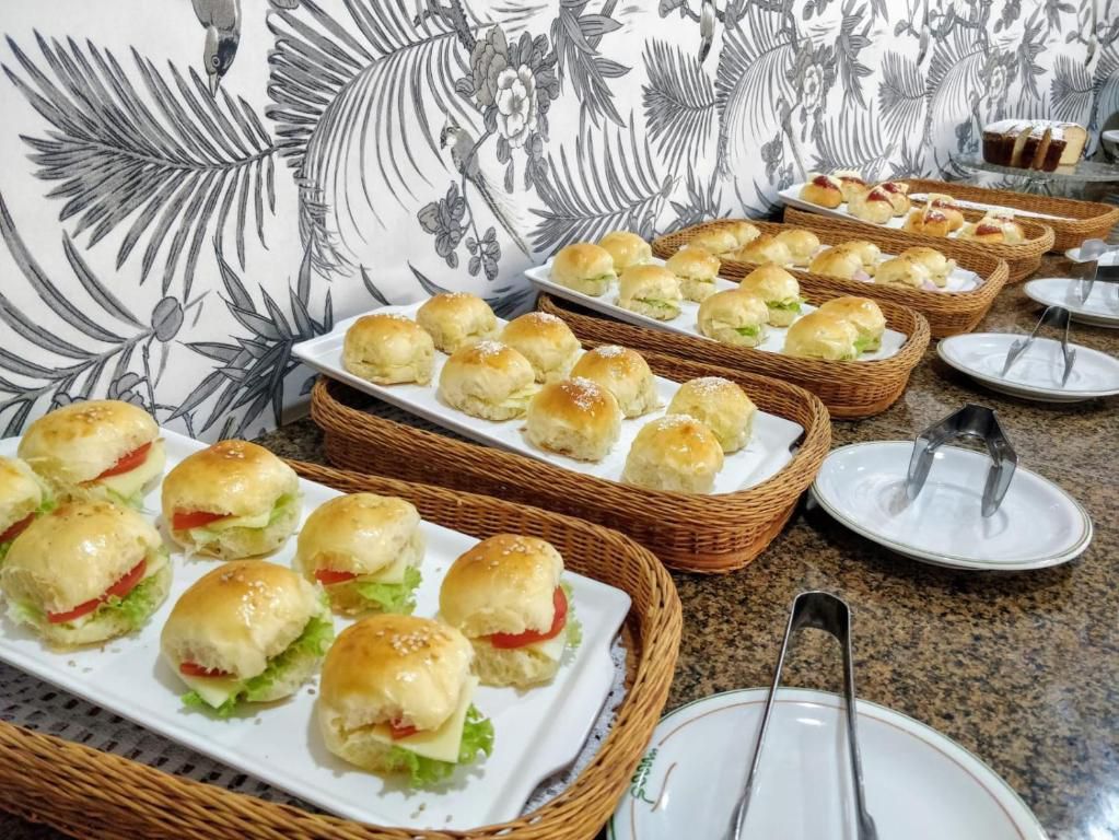 Vários sanduíches estão em pratos sobre uma mesa.