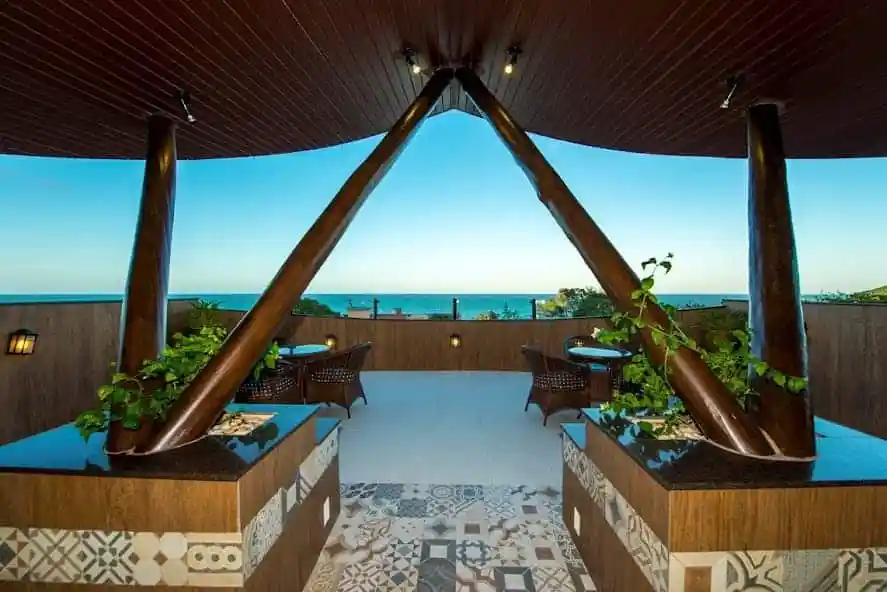 Uma varanda com vista para o oceano e mesas e cadeiras