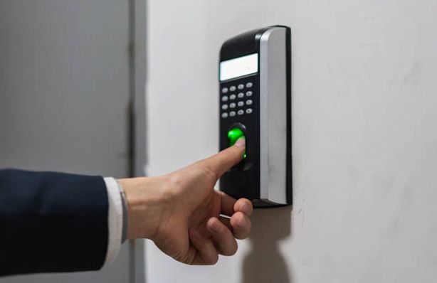 Man putting thumb on a biometric access control system