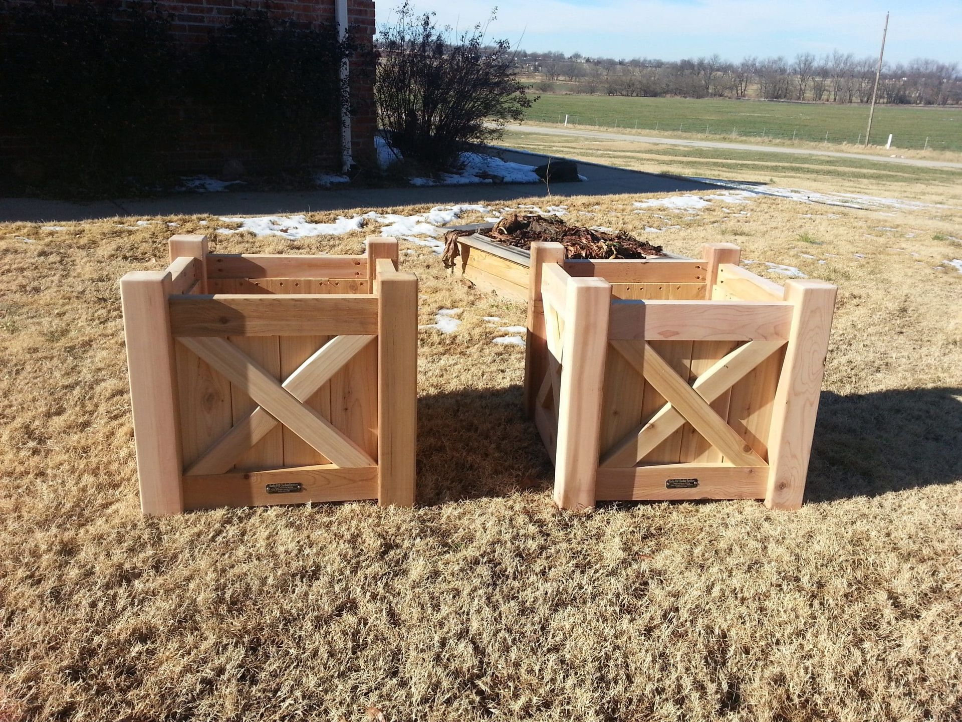 Two wooden boxes are sitting on a grassy field