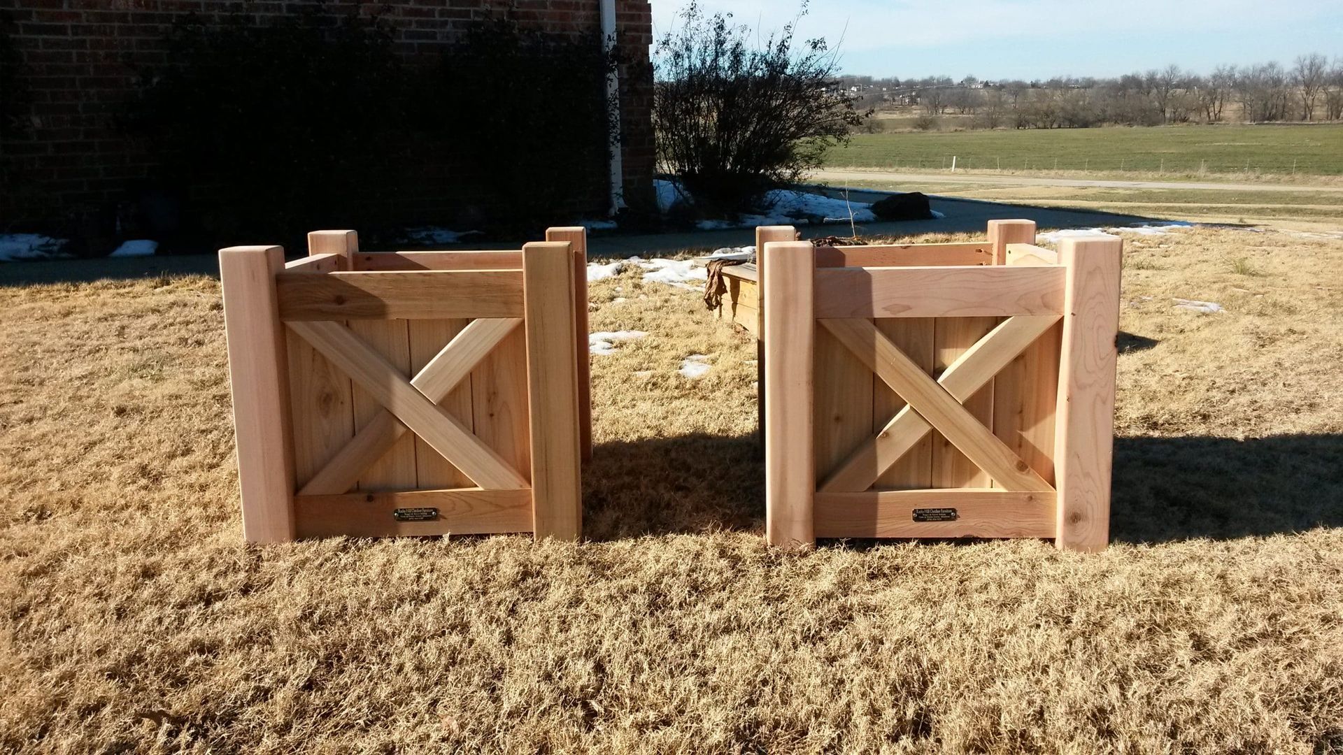 Two wooden boxes with crosses on them are sitting in the grass