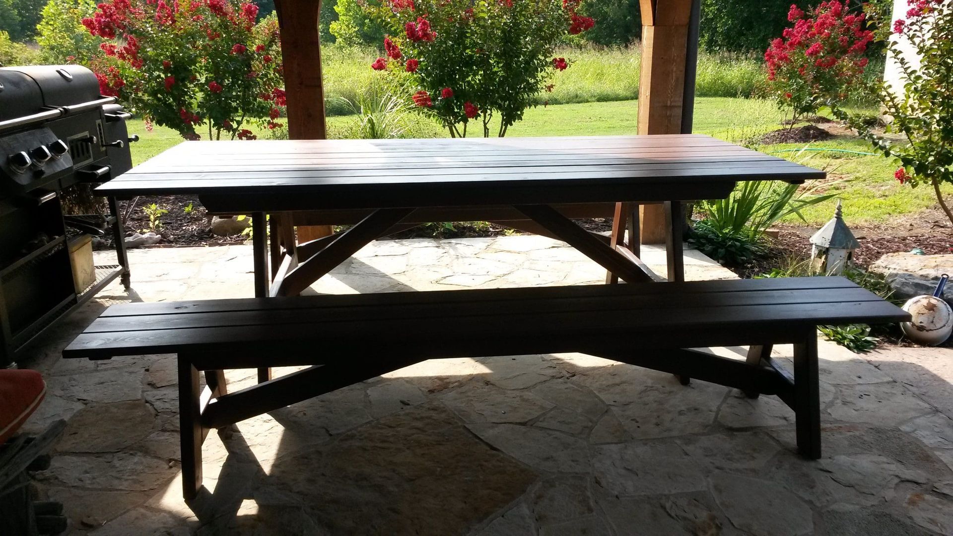 A wooden picnic table with a bench underneath it