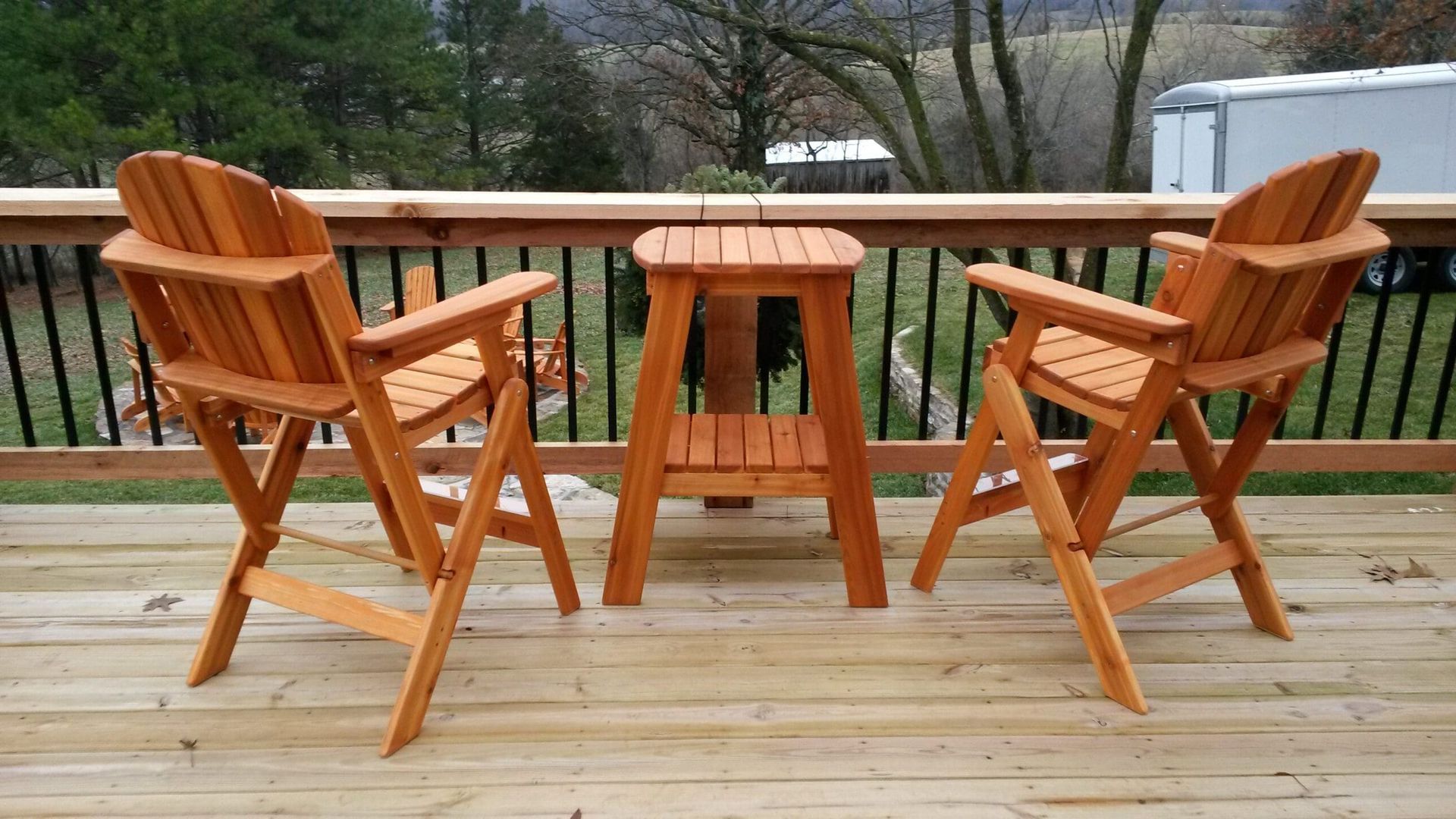 Two wooden chairs and a table on a wooden deck
