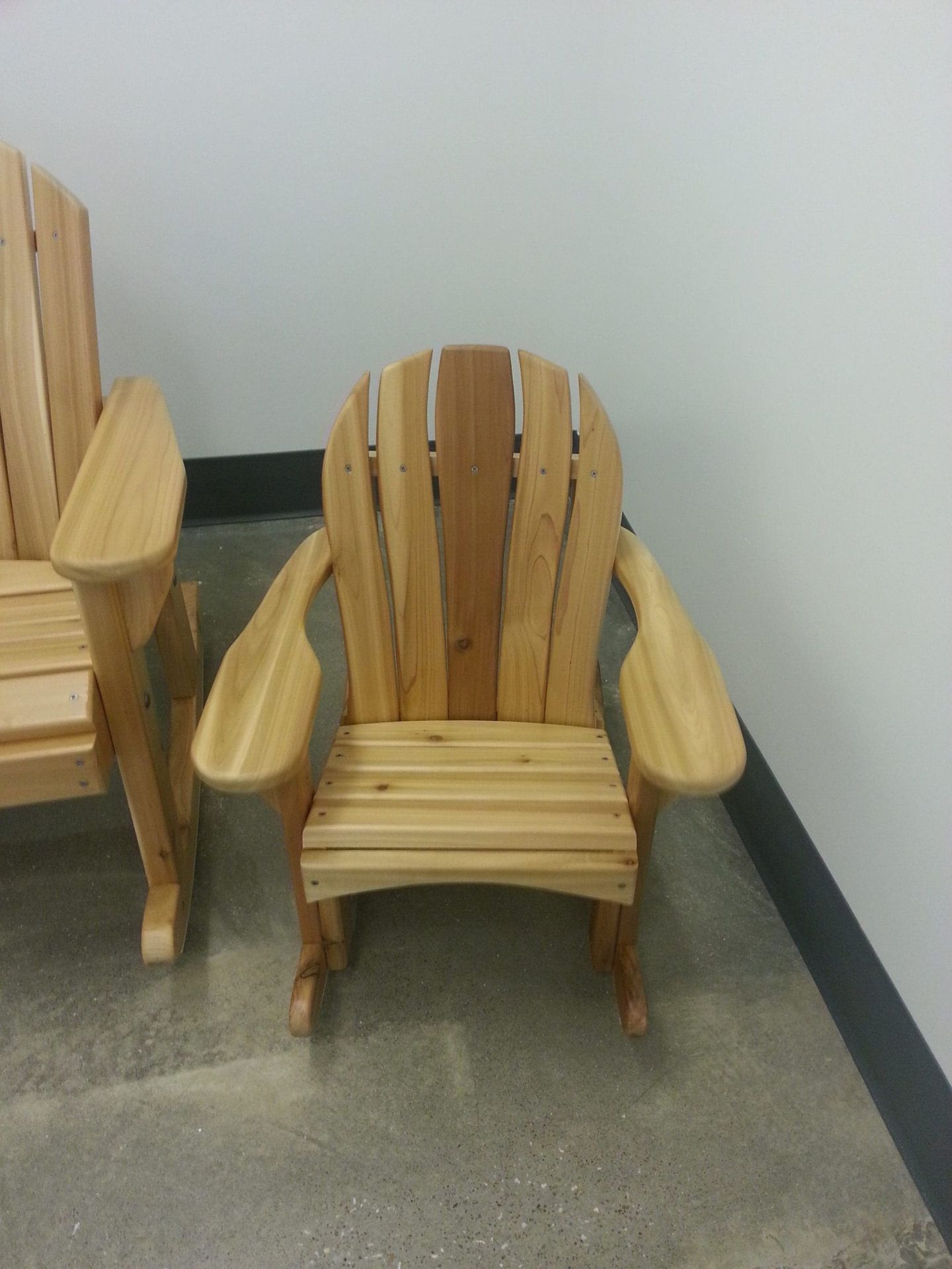 A wooden chair is sitting in a room next to another chair