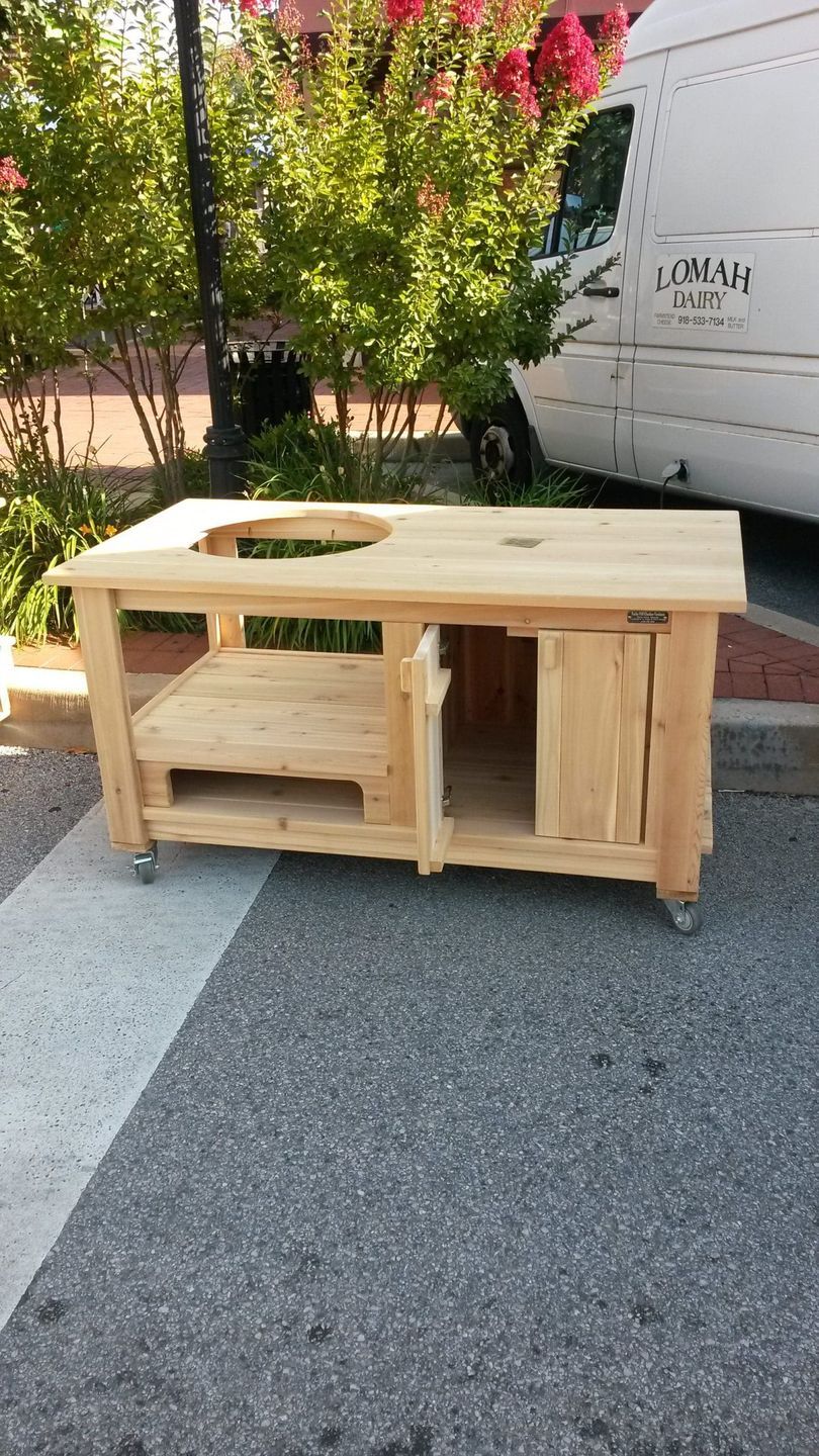 A wooden table is sitting on the side of the road next to a white van.