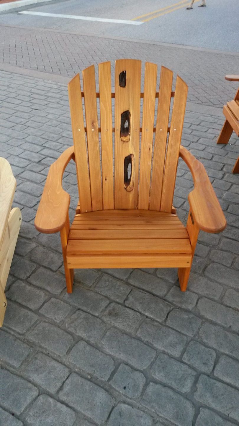 A wooden chair is sitting on a brick sidewalk