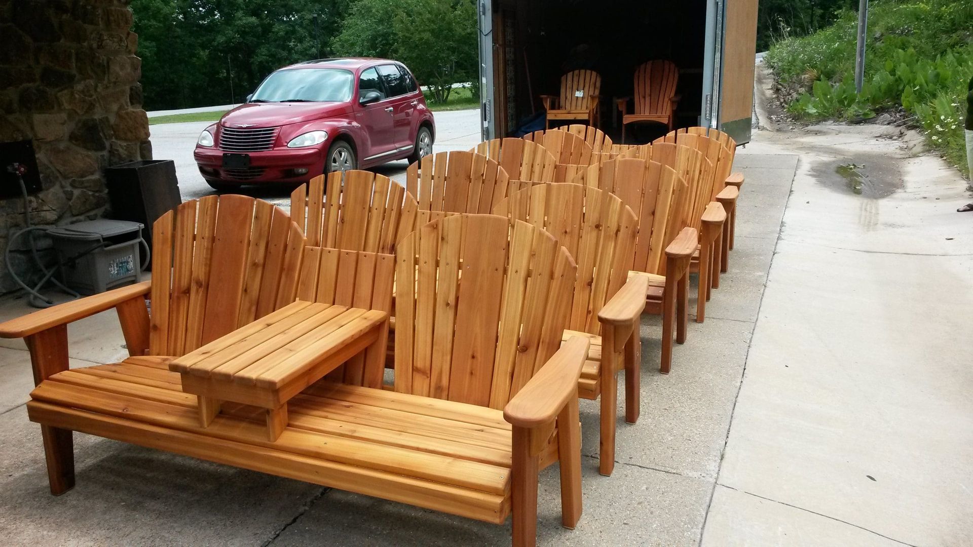 A row of wooden chairs are lined up in front of a truck