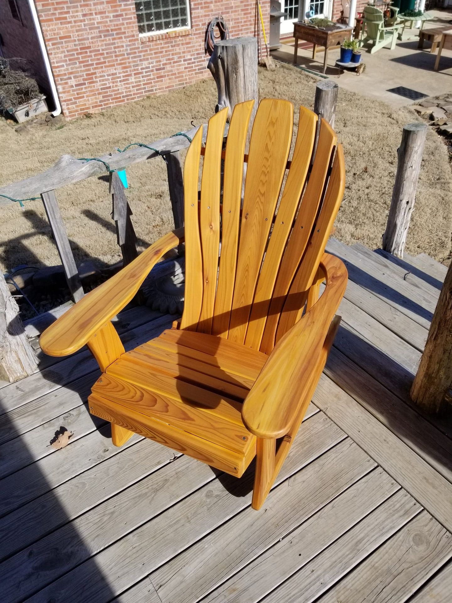 A wooden chair is sitting on a wooden deck.