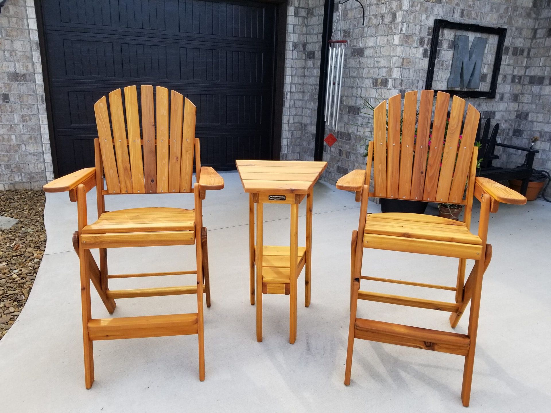 Three wooden chairs and a table in front of a garage door