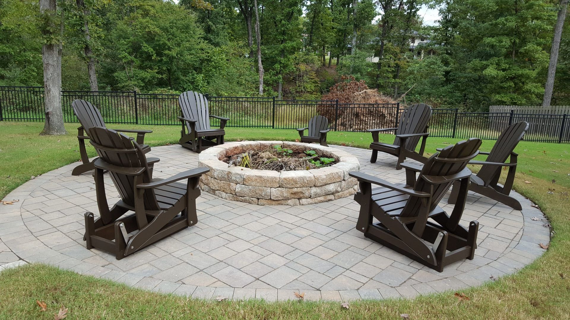 A group of chairs are sitting around a fire pit.